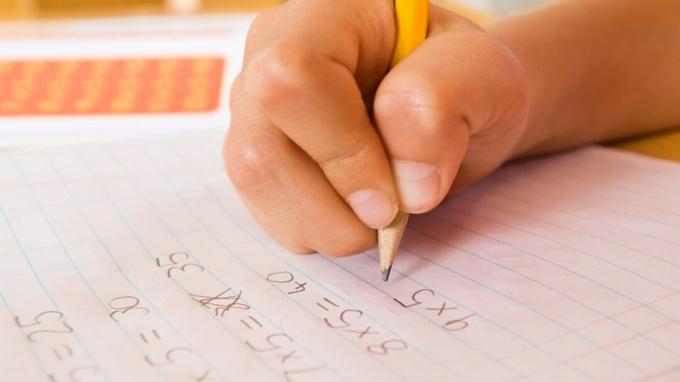Bir çocuğun elini matematik konaklama yardımı ile ödev